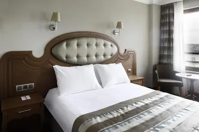 a bedroom with a large bed with a wooden headboard at Grand Halic Goldenhorn in Istanbul