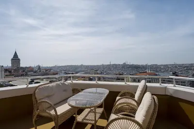 a balcony with chairs and tables and a view of a city at Continental Hotel Pera in Istanbul