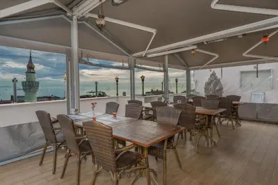 a restaurant with tables and chairs and a view of the water at Antis Hotel-Special Category in Istanbul