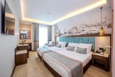 a hotel room with a large bed and a desk at Grand Hilarium Hotel in Istanbul