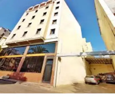 a tall white building with a car parked in front of it at Orient Mintur Hotel in Istanbul