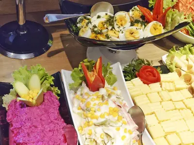a table topped with different types of cheese and vegetables at Orient Mintur Hotel in Istanbul