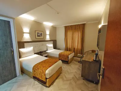 a hotel room with two beds and a television at Orient Mintur Hotel in Istanbul