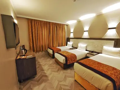 a hotel room with two beds and a flat screen tv at Orient Mintur Hotel in Istanbul