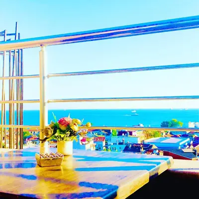 a table with a bouquet of flowers on a balcony at Theodian Hotel in Istanbul
