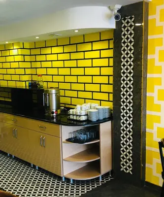 a kitchen with a yellow tiled wall at Theodian Hotel in Istanbul