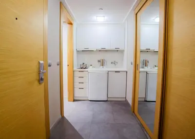 a small kitchen with white cabinets and a door at Housez Suites & Apartments Special Class in Istanbul