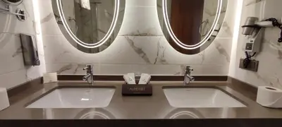 two sinks in a bathroom with two mirrors at Cihangir Hotel Bosphorus in Istanbul
