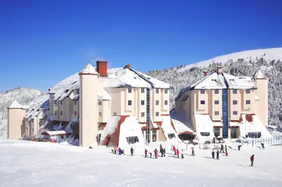 a group of people standing in the snow in front of a building at Monte Baia Uludağ in Uludag