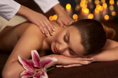 a woman getting a back massage with a pink flower at Harmony Hotel Istanbul & SPA in Istanbul