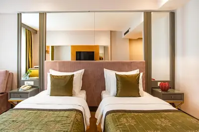 a hotel room with two beds and a mirror at Oran Hotel in Istanbul