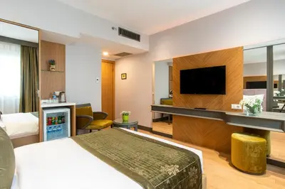 a hotel room with a bed and a flat screen tv at Oran Hotel in Istanbul