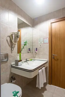 a bathroom with a sink and a toilet and a mirror at Oran Hotel in Istanbul