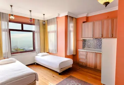 a room with two beds and a kitchen with orange walls at Bucoleon by Cheers in Istanbul