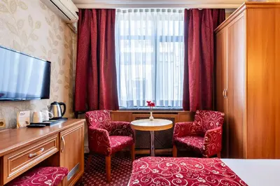 a room with red chairs and a table and a tv at Hotel Bristol in Istanbul