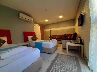 a hotel room with two beds and a couch at 216 Turkuaz Suit in Istanbul