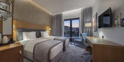 a hotel room with a large bed and a desk and a desk at Holiday Inn Istanbul - Tuzla Bay by IHG in Istanbul