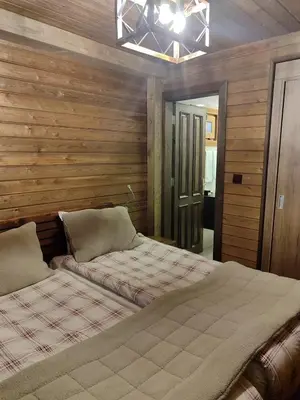 a bedroom with two beds and a chandelier at Karinna Orman Evleri in Uludag