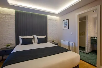 a bedroom with a large white bed with blue pillows at Moss Suites Hotel in Istanbul