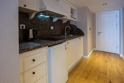 a kitchen with white cabinets and a sink at Moss Suites Hotel in Istanbul