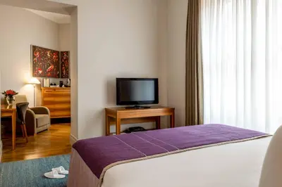 a hotel room with a bed and a flat screen tv at Tomtom Suites in Istanbul
