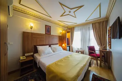 a hotel room with a large bed and a chair at Apart Hotel Hippodrome in Istanbul