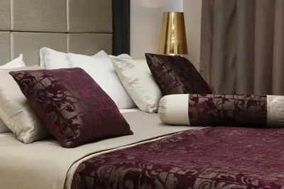 a bed with burgundy and white pillows on it at Mirilayon Hotel - Old Town in Istanbul