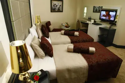 a hotel room with two beds and a television at Mirilayon Hotel - Old Town in Istanbul