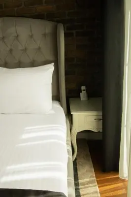 a bedroom with a bed and a night stand with a telephone at Louis Rooms in Istanbul