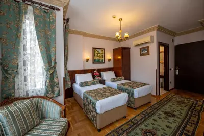 a hotel room with two beds and a couch at Osmanhan Hotel in Istanbul