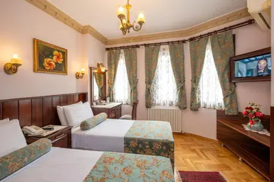 a hotel room with two beds and a television at Osmanhan Hotel in Istanbul