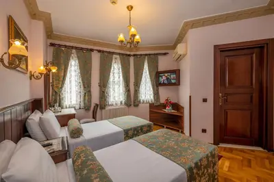 a hotel room with two beds and a couch at Osmanhan Hotel in Istanbul