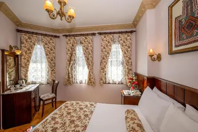 a bedroom with a bed and a desk and window at Osmanhan Hotel in Istanbul