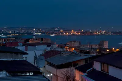 a city at night with the water and buildings at Osmanhan Hotel in Istanbul