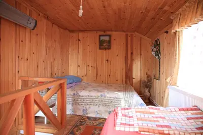 a bedroom with a bed in a wooden cabin at Zirve Dağ Evi in Kocaeli