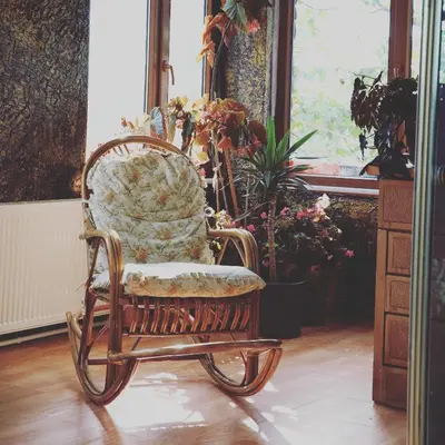 a wooden rocking chair sitting in a room with flowers at Zirve Dağ Evi in Kocaeli
