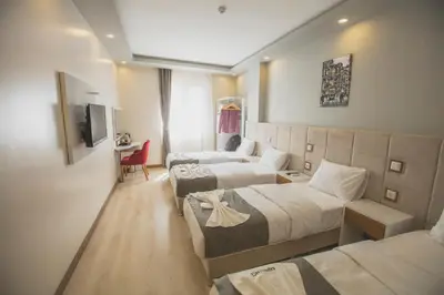 a hotel room with two beds and a couch at Express İnci Hotel in Istanbul