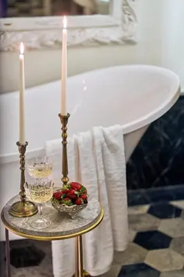 a table with two candles and a bowl of fruit and a bath tub at Mr Cas Hotels Taksim - Special Category in Istanbul