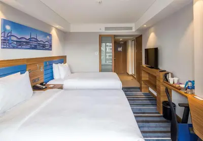 a hotel room with two beds and a flat screen tv at Hampton by Hilton Istanbul Kurtkoy in Istanbul
