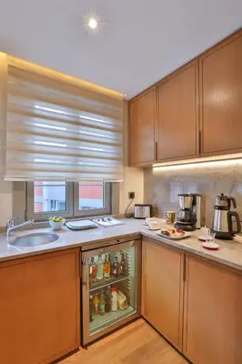 a kitchen with wooden cabinets and an open refrigerator at Ada Suites Nisantasi in Istanbul