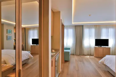 a hotel room with two beds and a mirror at Ada Suites Nisantasi in Istanbul