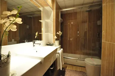 a bathroom with a sink and a shower and a tub at Hotel Buyuk Sahinler in Istanbul