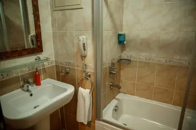 a bathroom with a sink and a shower and a phone at Yuksel Hotel in Istanbul