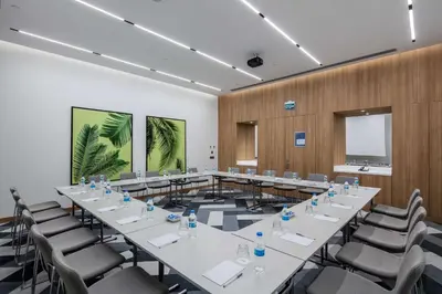 a conference room with tables and chairs and a screen at Hampton by Hilton Istanbul Zeytinburnu in Istanbul