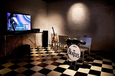 a room with a table with a guitar and a tv at Point Hotel Barbaros in Istanbul