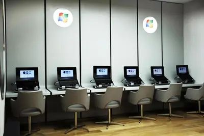a row of laptops sitting on a counter with chairs at Point Hotel Barbaros in Istanbul