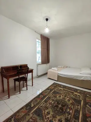 a bedroom with a bed and a desk and a bed and a piano at Apartament Ada in Buyukada