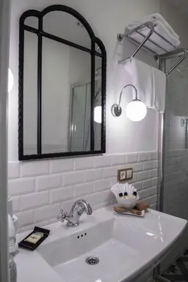 a white bathroom with a sink and a mirror at Rodosto Hotel in Tekirdag