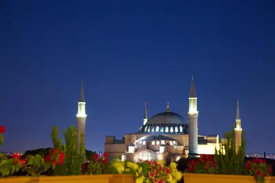 a building with a mosque with domes at night at White House Hotel Istanbul in Istanbul