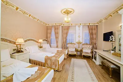 a hotel room with two beds and a desk at White House Hotel Istanbul in Istanbul